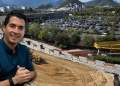 Smiling Man in a Teal Polo Stands at the Edge of a Construction Site Overlooking a Costco Store and a Busy Parking Lot with Hills in the Background. - Capitanes Regios