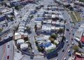 Aerial View of a Dense Residential Area with a Circular Road Loop Around a Block of White and Beige Houses. - Capitanes Regios