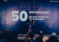 Man at a Podium Delivering a Speech in Front of a Large Banner Reading '50 Aniversario' and 'gobierno De Monterrey'. - Capitanes Regios