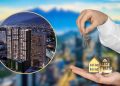 Two Hands Hold a Small Model House and Keys in Front of a Blurred City Skyline, Suggesting Property Ownership or Real Estate Investment. - Capitanes Regios